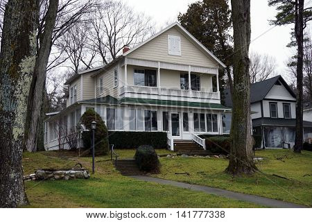 WEQUETONSING, MICHIGAN / UNITED STATES - DECEMBER 22, 2015: An elegant home with an enclosed front porch and a balcony on Beach Drive in Wequetonsing.