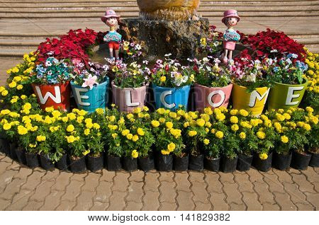 Thai pot with welcome sign, art in garden