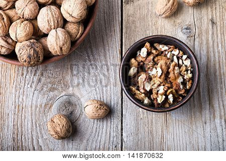 walnuts in a bowl on a wooden background