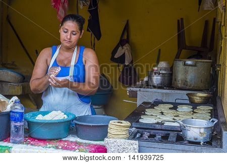 SUCHITOTO EL SALVADOR - MAY 07 : Salvadoran woman prepares Popusas in Suchitoto El Salvador on May 07 2016. Popusa is a traditional Salvadoran dish made of corn tortilla