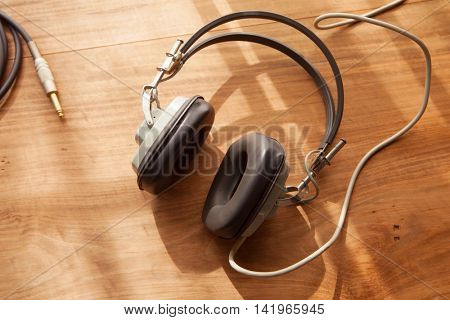 Listening to music. Headphones on a wooden desk.