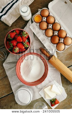 Raw Ingredients For Cooking Strawberry Pie Or Cake On Wooden Table (eggs, Flour, Milk, Sugar, Strawb