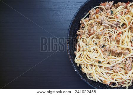 Appetizing Spaghetti In An Old Frying Pan With Bolognese Sauce On A Dark Background Close Up And Cop