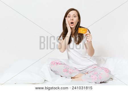 Young Fun Happy Woman Sitting In Bed With White Sheet, Pillow, Wrapping In Blanket On White Backgrou