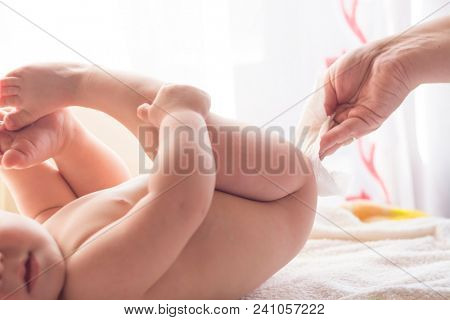 Hygiene - young momy wiping the baby skin with wet wipes. Cleaning wipe, pure, clean