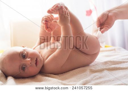 Hygiene - young momy wiping the baby skin with wet wipes. Cleaning wipe, pure, clean