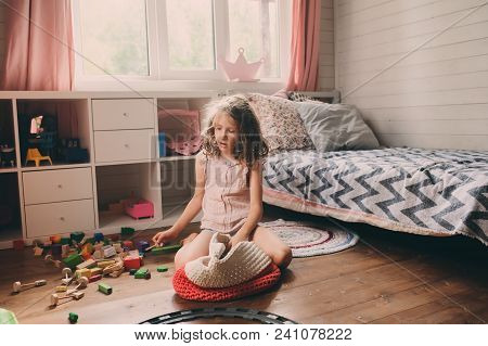 Child Girl Cleaning Her Messy Room And Put Toys In Basket