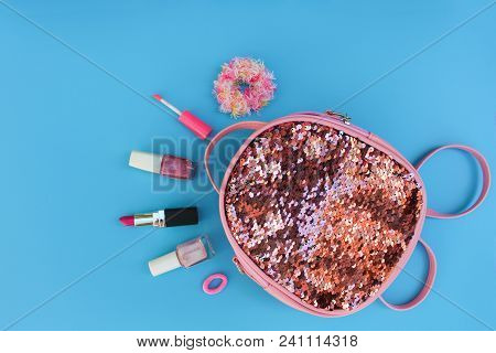 Female Backpack With Cosmetics And Womens Accessories On Blue Background. Top View, Flat Lay.