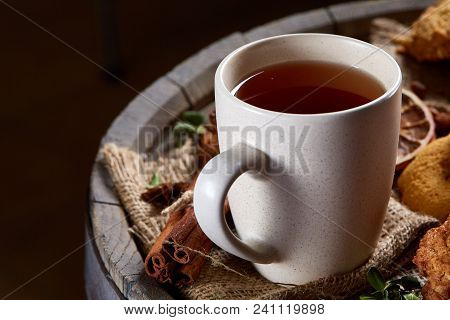 Conceptual Festive Composition With A Cup Of Hot Tea, A Large Set Of Cookies, Cinnamon Sticks Bunch 