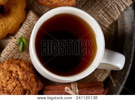 Top View Festive Composition With A Cup Of Hot Tea, A Large Set Of Cookies, Cinnamon Sticks Bunch An
