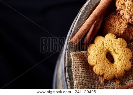 Conceptual Composition With Assortment Of Cookies On Burlap Napkin Covering A Wooden Barrel Over Rus