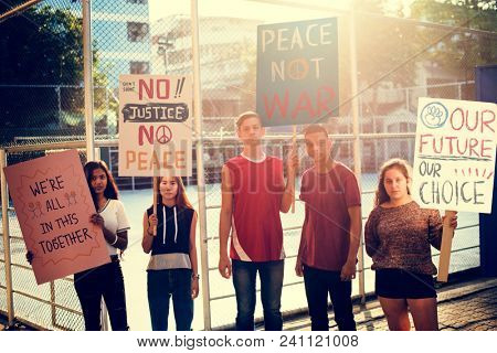 Group of teenagers protesting demonstration holding posters antiwar justice peace concept