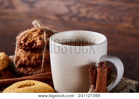 Conceptual Festive Composition With A Cup Of Hot Tea, A Large Set Of Cookies, Cinnamon Sticks Bunch 