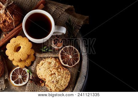 Conceptual Festive Composition With A Cup Of Hot Tea, A Large Set Of Cookies, Cinnamon Sticks Bunch 