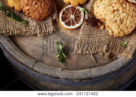 Conceptual Composition With Assortment Of Cookies, Cinnamon Sticks Bunch And Dried Oranges On Burlap