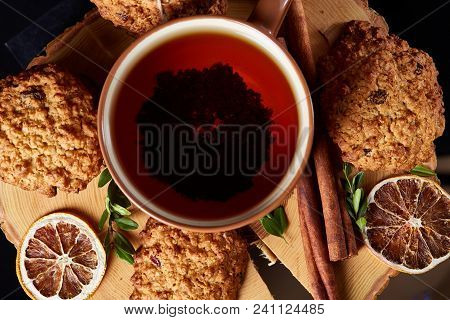 Christmas Concept With A Cup Of Hot Tea, A Large Set Of Cookies, Cinnamon Sticks Bunch, A Couple Of 