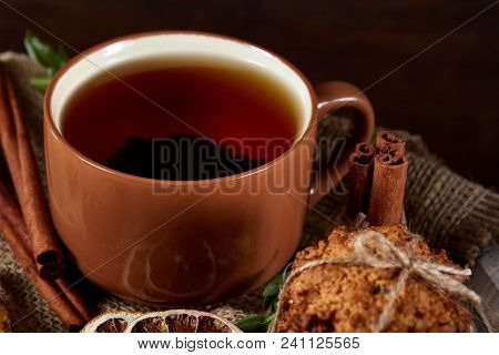 Conceptual Festive Composition With A Cup Of Hot Tea, A Large Set Of Cookies, Cinnamon Sticks Bunch 