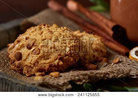 Conceptual Composition With A Couple Of Cookies, Cinnamon Sticks Bunch On A Wooden Barrel Over Rusti