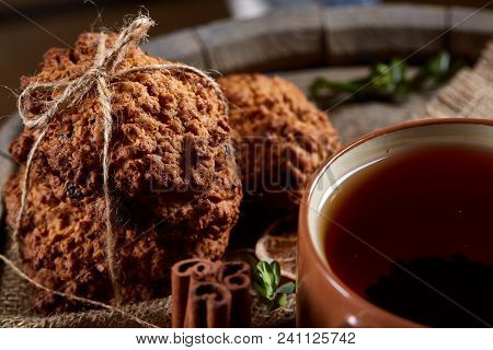 Conceptual Festive Composition With A Cup Of Hot Tea, A Large Set Of Cookies, Cinnamon Sticks Bunch 