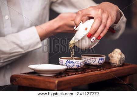Cropped Shot Of Woman Brewing Tea In Traditional Chinese Teaware.