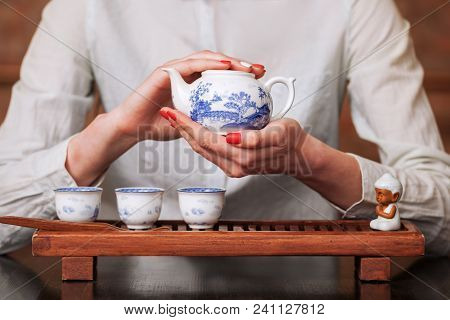 Cropped Shot Of Woman Pouring Tea In Traditional Chinese Teaware.
