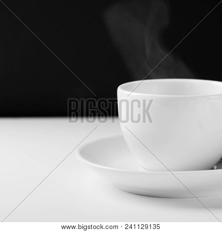 White Mug For Tea With A Hot Drink On A White Wooden Table On A Black Background. Close Up