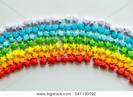 Colorful orgami stars forming a rainbow background