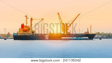 Vessel Working With Crane On A River With Sunset Lighting.