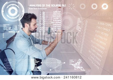 Drawing Carefully. Attentive Calm Experienced Designer Holding A Modern Stylus While Sitting Alone A