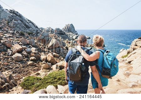 Couple Looking At The Sea And Rocks At Capo Testa, Santa Teresa Gallura, Sardinia, Italy