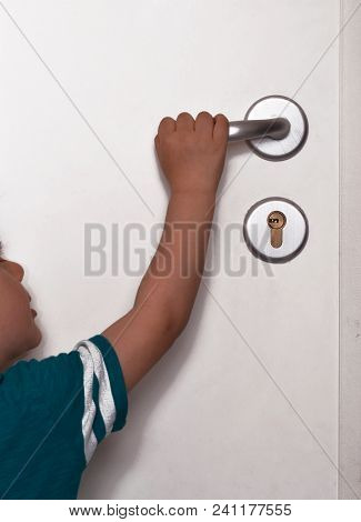Little kid trying to open the home door handle.