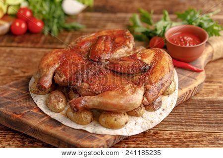 Delicious Tobacco Chicken On A Wooden Background With Fresh Vegetables. Rustic.