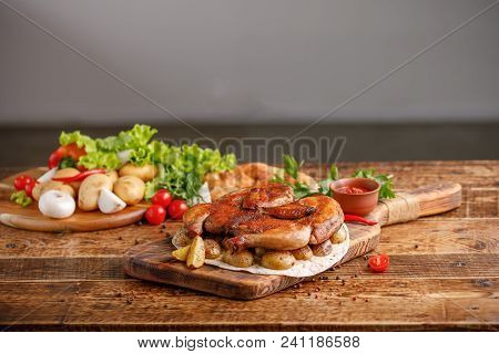 Fried Chicken With Garnish Of Baked Young Potatoes With Fresh Vegetables. Appetizing Still Life On A