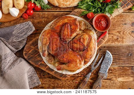 Appetizing Chicken Tobacco On A Wooden Background. Still Life With Textiles And Original Devices. To