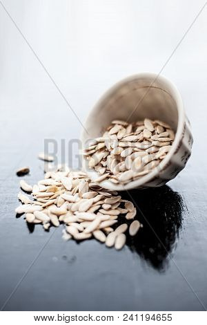 Edible Dried Raw Organic Seeds Of Musk Melon Or Cantaloupe Or Tati Or Honeydew On A Wooden Surface.