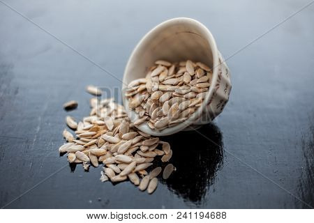 Edible Dried Raw Organic Seeds Of Musk Melon Or Cantaloupe Or Tati Or Honeydew On A Wooden Surface.