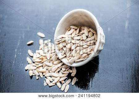 Edible Dried Raw Organic Seeds Of Musk Melon Or Cantaloupe Or Tati Or Honeydew On A Wooden Surface.
