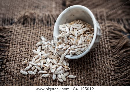 Edible Dried Raw Organic Seeds Of Musk Melon Or Cantaloupe Or Tati Or Honeydew On A Wooden Surface.