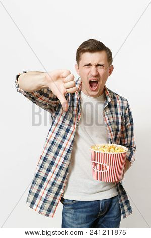 Portrait Of Young Irritated Angry Handsome Man In Casual Clothes Watching Movie Film, Holding Bucket