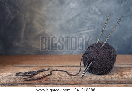 Brown Yarn Ball With Scissors On A Rustic Wooden Background, Toned, Wabi Sabi Style