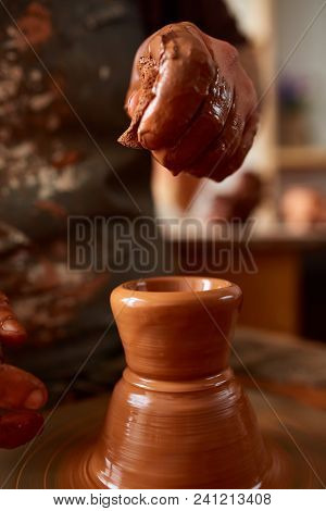 Close-up Hands Of A Male Potter In Plaid Shirt And Dirty Apron Who Molds Bowl From Clay, Selective F