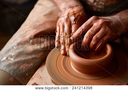 Close-up Hands Of A Male Potter In Plaid Shirt And Dirty Apron Who Molds Bowl From Clay, Selective F