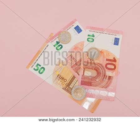 Euro Money: Closeup Of Banknotes And Coins On A Pink Background. Business Concept.
