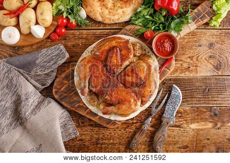 Seductive Chicken Of Tobacco On A Wooden Background. Still Life With Textiles And Original Cutlery.