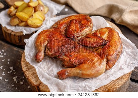Chicken Tobacco And Potato Garnish On Wooden Spilah. Close-up.