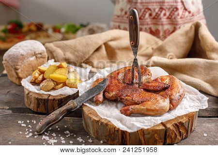 Appetizing Chicken And Potato Garnish On Wooden Spilah.natyurmort With Original Cutlery And Textiles