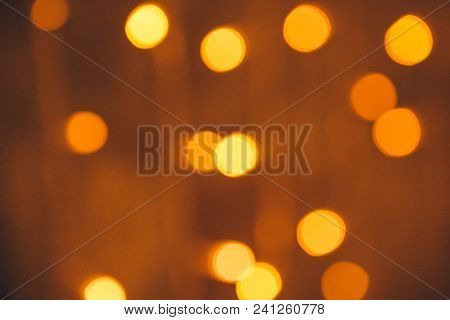 Many Blurred Small Electric Bulbs On A Wall. Yellow Blurred Lights. Wall Of Christmas Lights