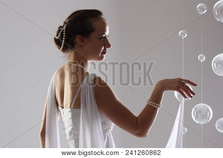 Girl In White And With Raised Hands, Attached To The Floor Dresses. The Bride In A Dress In Greek St
