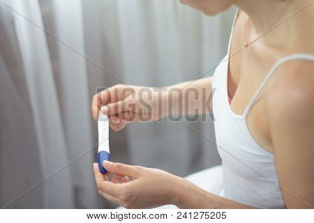 Young Woman With Pregnancy Test In Hands. The Test Shows A Positive Result