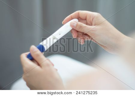 Young Woman With Pregnancy Test In Hands. The Test Shows A Positive Result